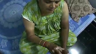 Mature and happy Indian aunty giving oily handjob on cam