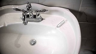 In a kitchen a sexy brunette playing with her big boobs